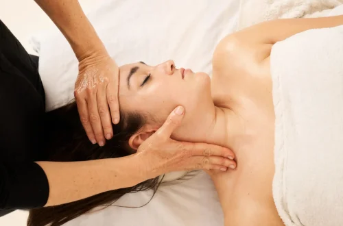 woman receiving a facial massage in the area of the cervicals